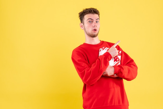 Front view young male in red shirt with christmas present