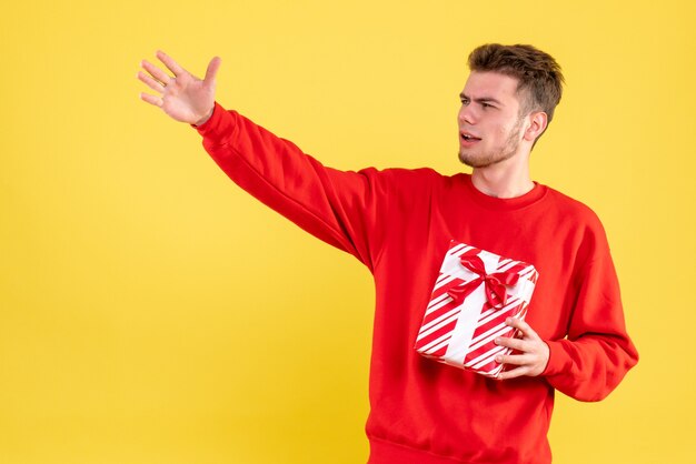 Front view young male in red shirt with christmas present