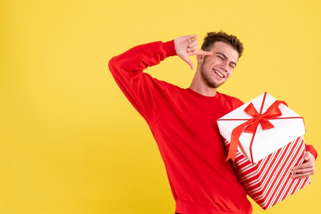 クリスマスプレゼントと赤いシャツの正面図若い男性