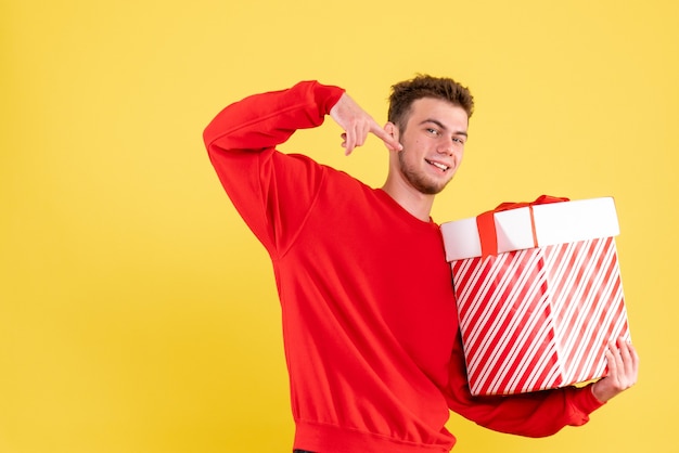 Front view young male in red shirt with christmas present