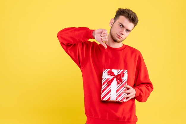 Front view young male in red shirt with christmas present