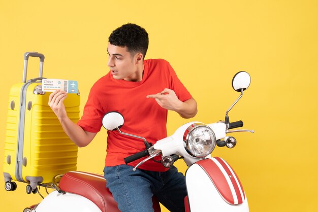 Front view young male in red t-shirt on moped holding ticket