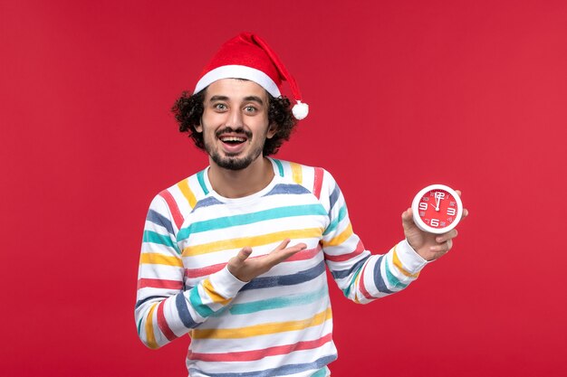 Front view young male rejoicing for new years coming on red wall time new year holidays