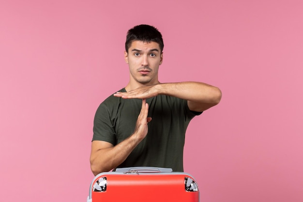 Front view young male showing t sign on pink space