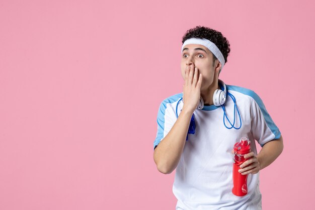Front view young male in sport clothes with skipping rope around his neck pink wall