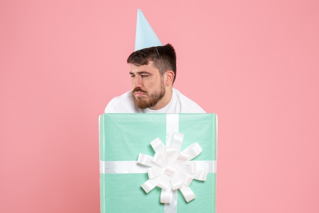 Front view young male standing inside present box on pink color pajama party photo emotion sleep human