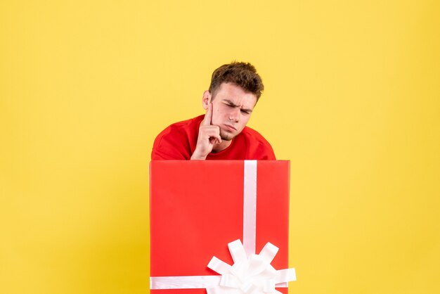 Front view young male standing inside present box stressed