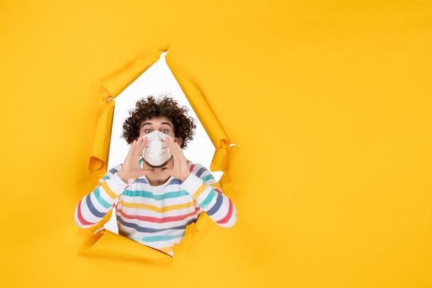 Free photo front view young male in sterile mask saying something on yellow color covid- health human pandemic virus photo