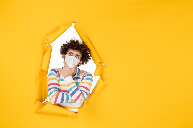 Free photo front view young male in sterile mask in thinking pose on yellow health color photo covid- pandemic virus human