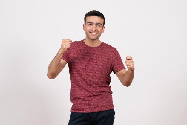 Front view young male in t-shirt posing and rejoicing on white background