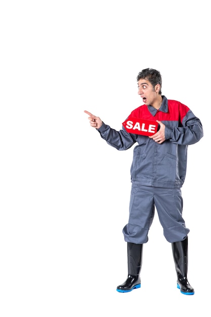 Front view young male in uniform holding sale nameplate on white surface