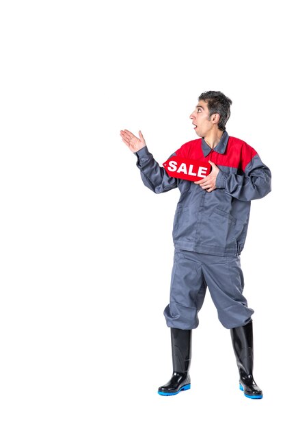 Front view young male in uniform holding sale nameplate on white surface