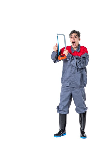 Front view young male in uniform with hacksaw on white background knife photo architecture hardwork building digger worker