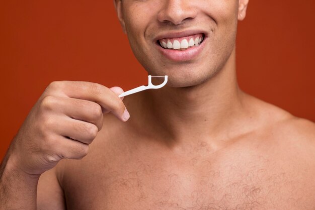 Front view young male using dental floss