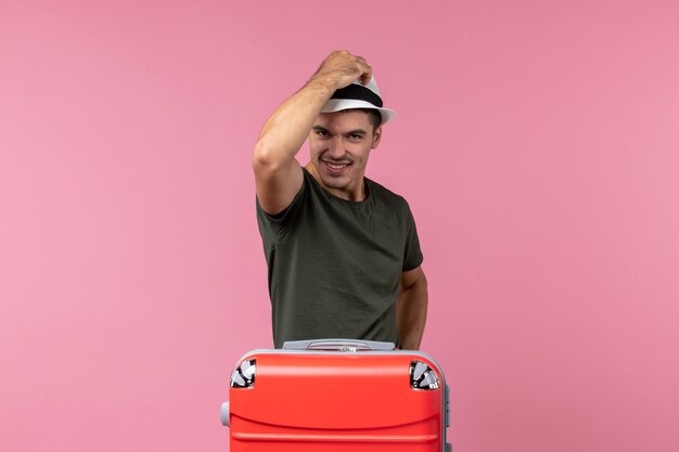 Вид спереди молодой мужчина в отпуске в шляпе на розовом пространстве