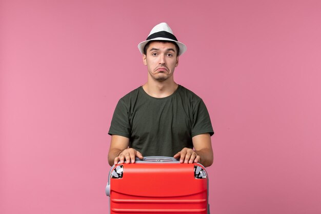 Front view young male in vacation with his red bag on pink desk