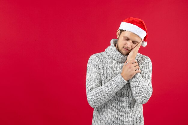 Front view young male in warm jersey feeling tired on red wall