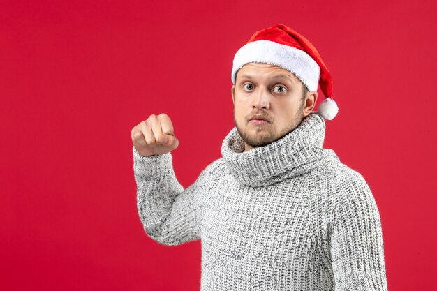 Front view young male in warm jersey preparing to hit on red background