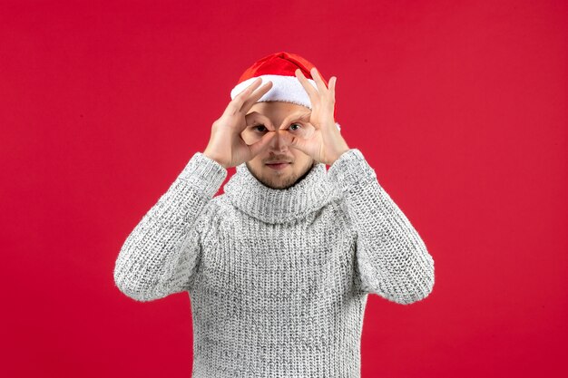 Front view young male in warm jersey on a red wall