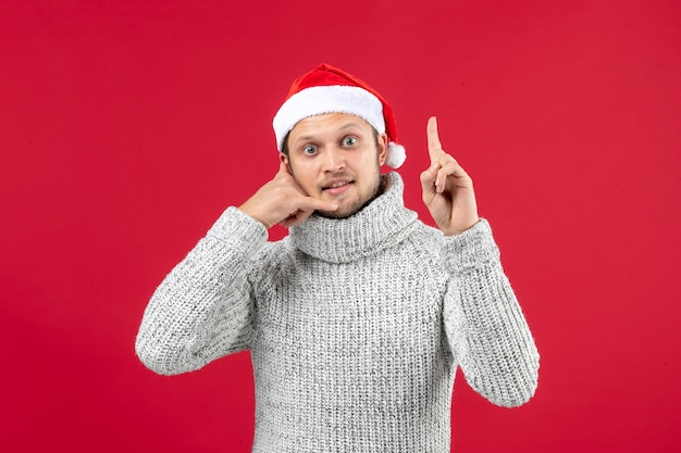 Front view young male in warm jersey on a red wall