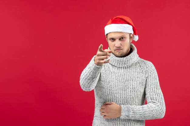 Front view young male in warm jersey on red wall