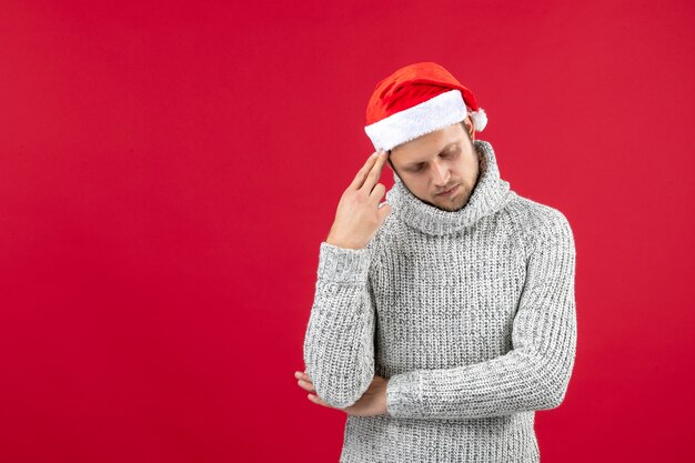 Front view young male in warm jersey on red wall