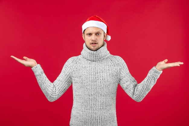 Front view young male in warm jersey on red wall