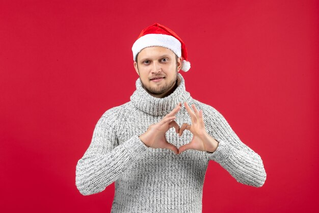 Front view young male in warm jersey sending love on red background