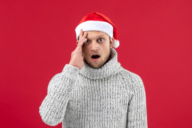 Front view young male in warm jersey surprised on red background