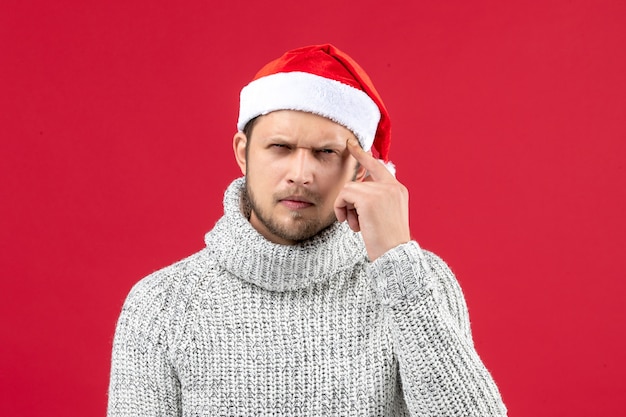 Free photo front view young male in warm jersey thinking deeply on red background