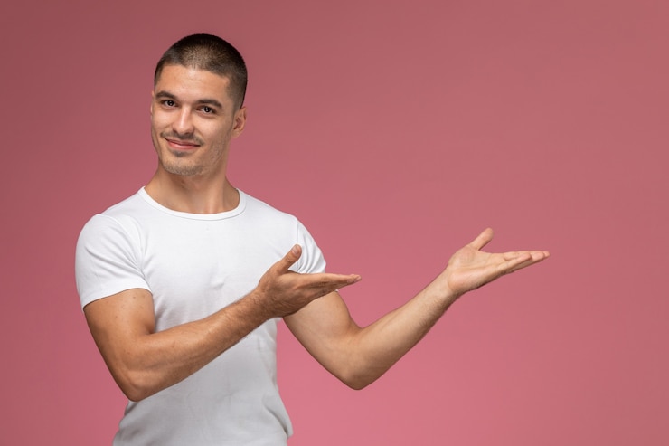 Free Photo front view young male in white shirt smiling and posing on pink background 
