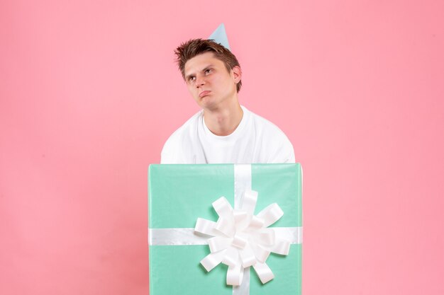 Front view young male in white shirt with cap and present on pink background