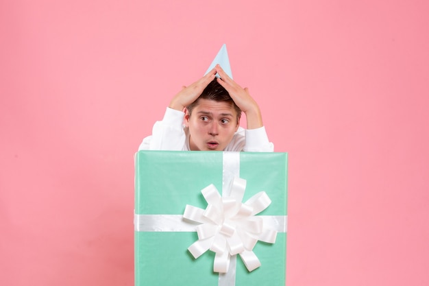 Free photo front view young male in white shirt with cap and present on pink background