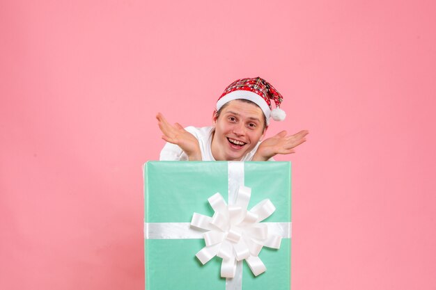 Front view young male in white shirt with present on pink background