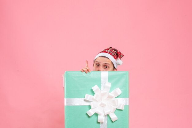 Front view young male in white shirt with present on pink background