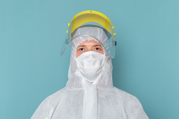 파란색 벽 남자 정장 위험 특수 장비 색상에 특수 머리 마스크를 쓰고 흰색 특수 양복에 전면보기 젊은 남성