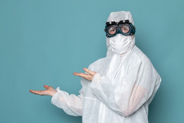 A front view young male in white special suit wearing special sunglasses on the blue wall man suit danger special equipment color