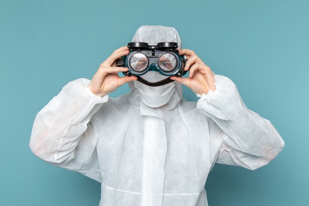 A front view young male in white special suit wearing special sunglasses on the blue wall man suit danger special equipment color