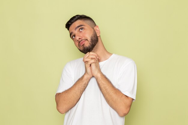 A front view young male in white t-shirt daydreaming