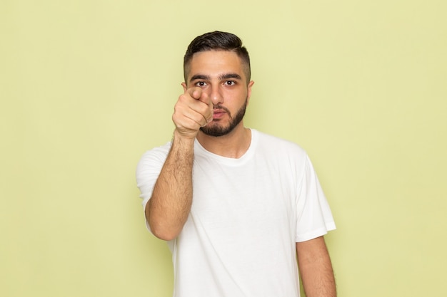 A front view young male in white t-shirt pointing out