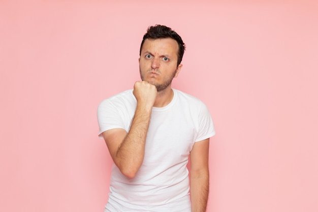 A front view young male in white t-shirt posing with aggressive expression