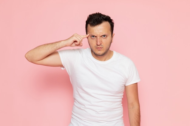 A front view young male in white t-shirt posing with angry expression