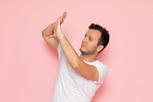 A front view young male in white t-shirt posing with cautious expression