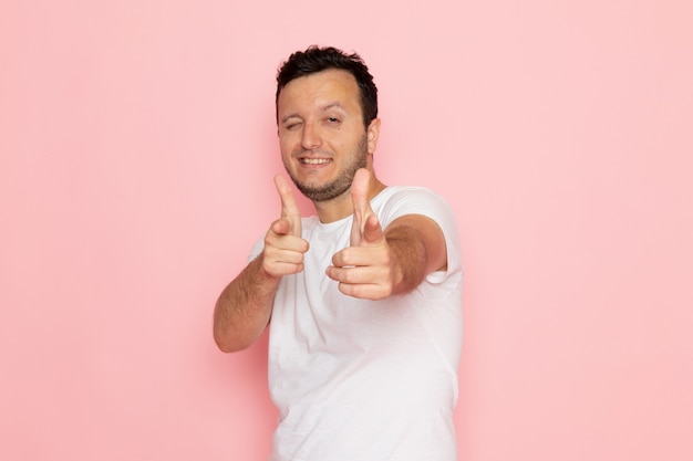 A front view young male in white t-shirt posing with funny expression