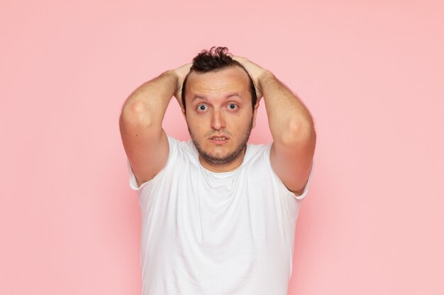 A front view young male in white t-shirt posing with surprised expression