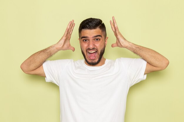 A front view young male in white t-shirt screaming out