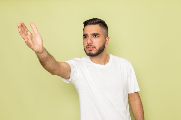 誰かに話している白いtシャツの正面の若い男性