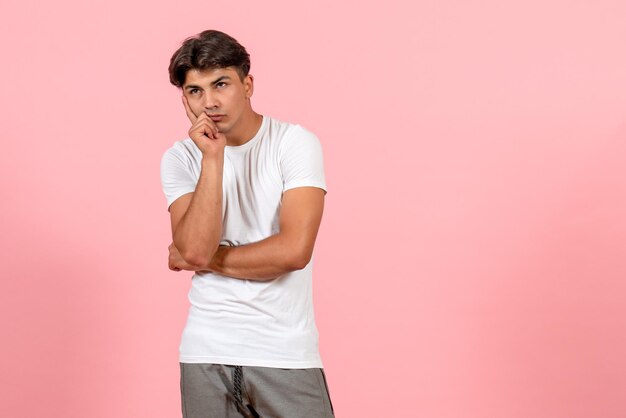 Front view young male in white t-shirt thinking on pink background