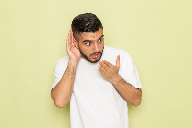 聞いてみようとする白いtシャツの正面の若い男性