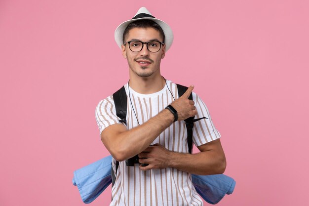 ピンクの背景にバッグと白いTシャツの正面図若い男性